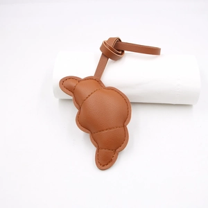 Charm borsa in pelle a forma di croissant marrone caramello con dettagli di cuciture