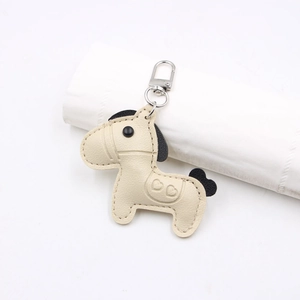 Detailed view of horse-shaped leather charm with heart patterns and silver clip