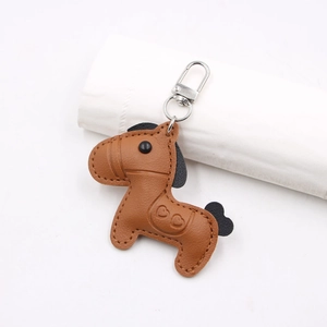 Close-up of brown pebbled leather horse keychain with heart embossing and silver clasp