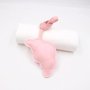 Dettaglio del ciondolo a croissant in pelle rosa con cuciture fini e cinturino lungo