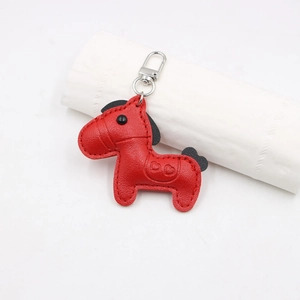 Macro shot of red leather pony charm with heart embossing and silver metal clasp