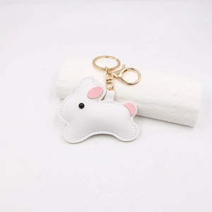 Close-up of white leather bunny charm with fine stitching and gold metal hardware
