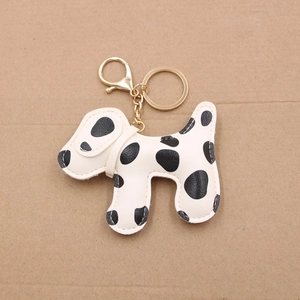 Detail of dalmatian leather keychain with white stitching and gold metal hardware