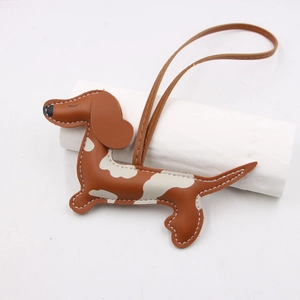 Détail de bijou de sac teckel en cuir marron avec surpiqûres et lanière assortie