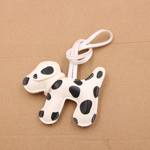 Detailed close-up of a dalmatian leather keychain featuring fine stitching and a white cord