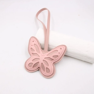 Pink faux leather butterfly keychain with hollow layered wings and pink stitching detail