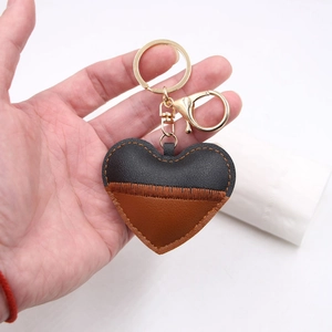 Handmade patchwork heart leather keychain with gold lobster clasp shown in hand