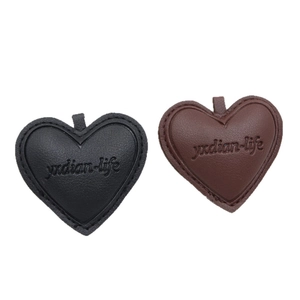 DIY leather heart-shaped pendants in black and brown colors with fine stitching details