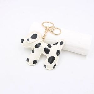 Close-up of Dalmatian dog leather keychain with fine white stitching and gold lobster clasp