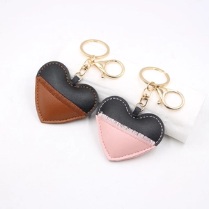 Handmade leather heart keychains in brown and pink color block with gold metal hardware