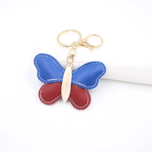 Close-up of leather butterfly keychain with royal blue and red color-blocked panels
