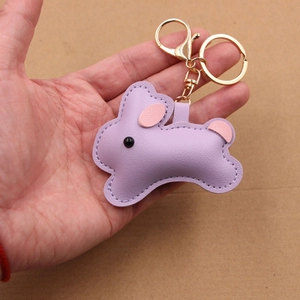 Cute purple leather bunny keychain with gold hardware and pink ear details in hand