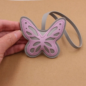 Close-up of double-layered hollow butterfly leather charm with stitching detail