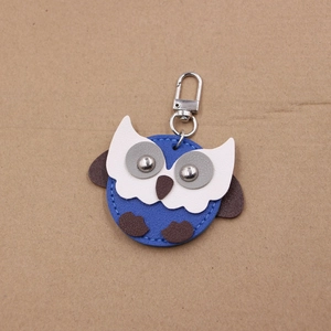 Close-up of owl leather keychain with detailed blue stitching and silver spring clasp