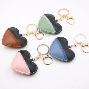 Handmade patchwork leather heart keychains with contrast stitching and gold metal hardware