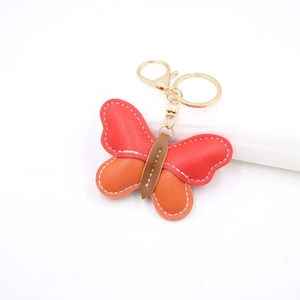 Detailed close-up of butterfly leather keychain with red and orange contrast stitching