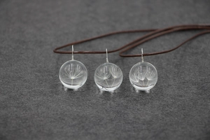 Vue détaillée des colliers en boule de verre avec graines de pissenlit et cordon