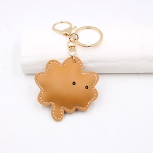 Detail of leaf-shaped brown leather keychain with gold lobster clasp and ring