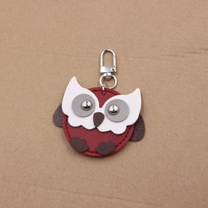 Detail of owl leather keychain with dark red texture and silver lobster clasp