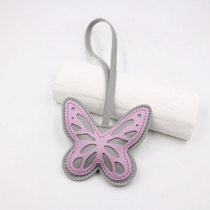Detail of pink and grey layered leather butterfly charm with hollow-out pattern and hand-stitching