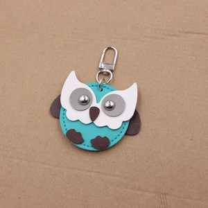 Close-up of blue leather owl keychain with detailed stitching and silver lobster clasp