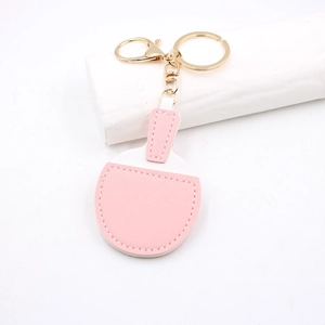 Close-up of pink and white leather table tennis paddle keychain with gold clasp