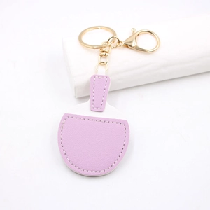 Close-up of purple and white leather ping pong paddle keychain with gold hardware