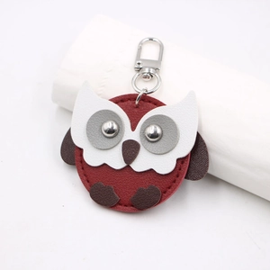 Close-up of owl-shaped leather keychain with pebbled texture and metal hardware buckle