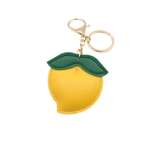 Thick faux leather peach fruit keychain in mango yellow with green leaf and golden clip