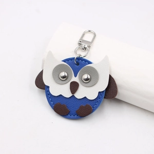 Macro detail of royal blue owl leather keychain showing litchi grain and silver rivets