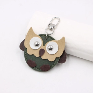 Detailed view of leather owl keychain with metal rivet eyes and premium stitching