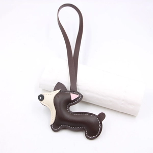 Dettaglio del ciondolo a forma di cucciolo Corgi in pelle con cuciture bianche e cinturino