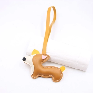 Dettaglio del ciondolo per borsa Corgi 3D in ecopelle con cordino giallo e cuciture bianche