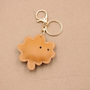 Close-up of yellow leather leaf pendant with white stitching and gold lobster clasp