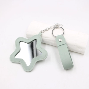 Détail du miroir porte-clés en cuir vert clair en forme d'étoile avec coutures fines