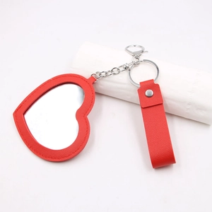 Détail du mini miroir porte-clés en cuir rouge en forme de cœur avec fermoir argenté