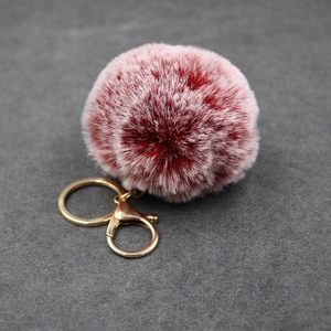 Plush faux rabbit fur keychain with red and white gradient ball and golden metal ring