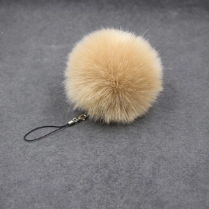 Close-up of fluffy 8cm beige faux fur ball keychain with silver metal lobster clasp detail