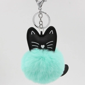 Detail of a mint green faux fur pompom keychain with a black leather cat head charm