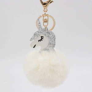 Close-up of fluffy white plush pom-pom with silver glitter unicorn head and golden clasp