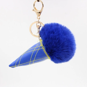 Detail of blue faux fur pom pom keychain with leather ice cream cone and gold clip