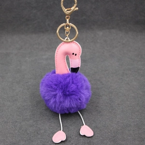 Détail d'un porte-clés flamant rose avec pompon en fourrure violette et fermoir doré