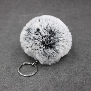 Close-up of soft faux fur keychain with white and grey gradient faux rabbit fur texture