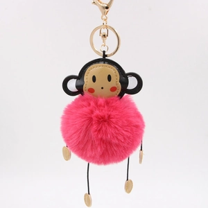 Detail of creative monkey plush keychain with soft pink fur ball and golden metal clasp