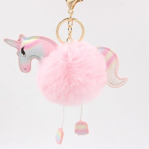Detail of pink faux fur pompom unicorn keychain with iridescent leather and gold clasp