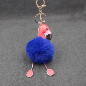 Gros plan du porte-clés flamant rose en fourrure bleu foncé avec mousqueton doré élégant