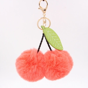 Détail du porte-clés cerise en peluche rose avec feuille verte et fermoir doré chic