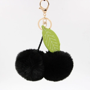 Détail du porte-clés cerise noir en fourrure avec feuilles vertes et fermoir doré
