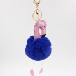 Détail du porte-clés flamant rose avec pompon en fausse fourrure bleue et paillettes