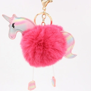 Close-up of fluffy pink unicorn pom pom keychain with holographic metallic details